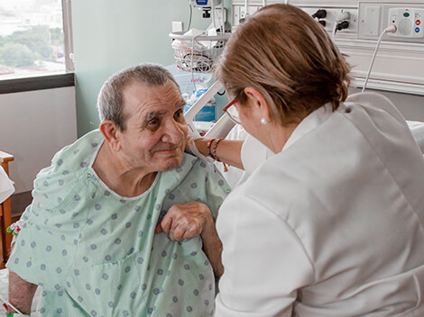Patient with a neurological condition being treated by a therapist at a critical illness hospital