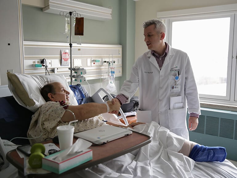 Doctor talking to a patient in a hospital bed, providing care and reassurance.