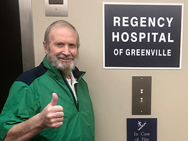 Art gives a thumbs-up sign standing next to the hospital elevator.