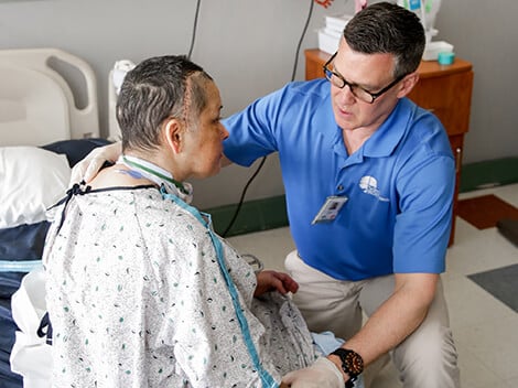 Patient with brain injury being treated by a therapist at a critical illness hospital